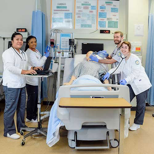 Nursing Instructor at Cecil College instructing student over hospital bed