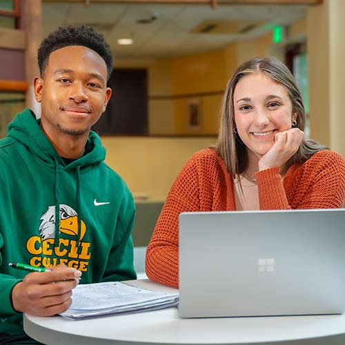 Cecil College student pointing to computer screen in visual communications lab