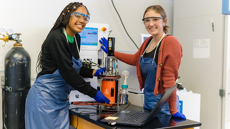 Cecil College Bioproduction Degrees - Two students in a lab using a scientific device.