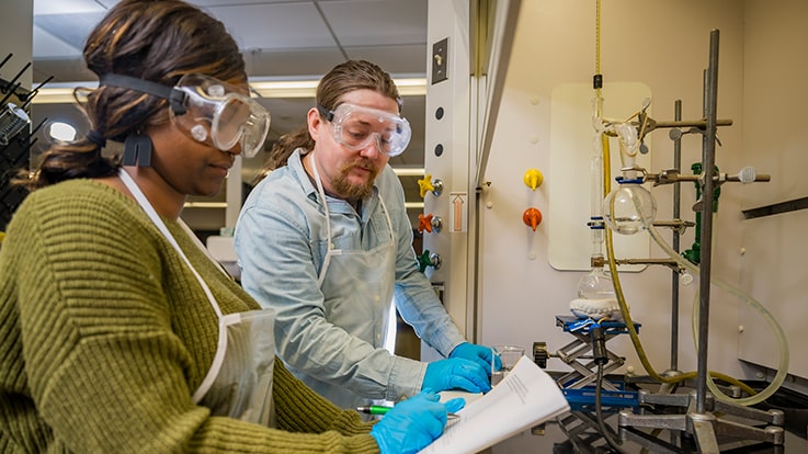 Cecil College Chemistry Degrees - Two students wearing safety gear and using chemistry equipment.