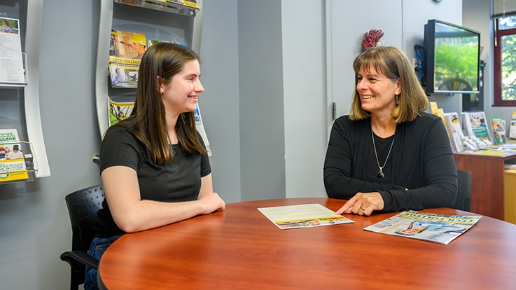 An admissions officer helping a prospective student.