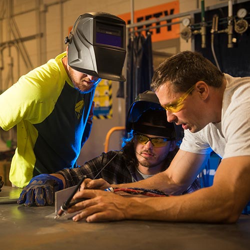 Two welding students with an instructor.